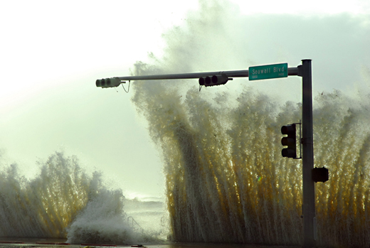 A wave splash higher than a traffic light on Seawall Blvd.