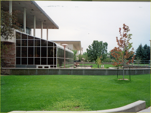 Concrete floodwall around a commercial building arranged into landscaping in a decorative way.